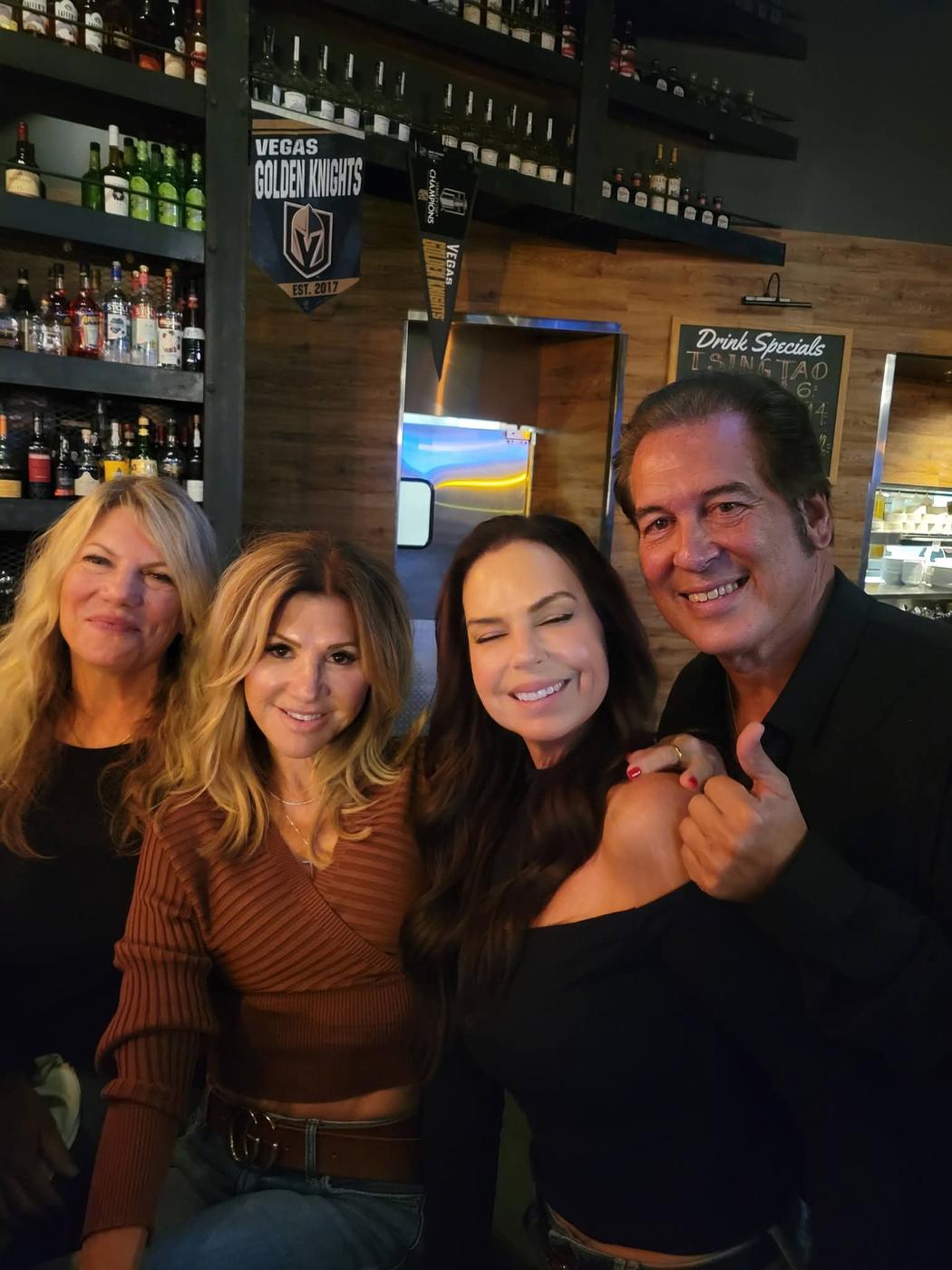 Four friends posing together at an evening show